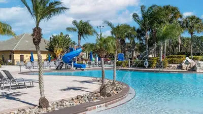 a pool at a resort with palm trees and a slide at BCH3027 in Kissimmee