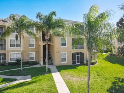 a house with palm trees in front of it at Spacious Windsor Palms Retreat - 11 Min to Disney in Kissimmee