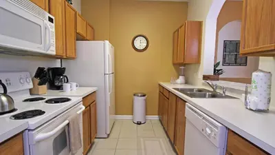 a kitchen with a white refrigerator and a clock on the wall at CW7660-303 Windsor Hills Resort Vacation Condo in Orlando