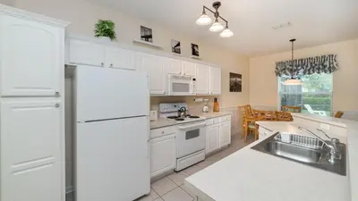 a kitchen with white cabinets and a white refrigerator at CW7705 Windsor Hills Resort Vacation Private Pool Home in Orlando