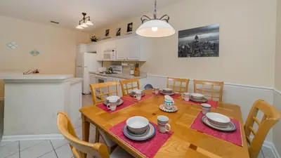 a kitchen and dining room with a wooden table and chairs at CW7705 Windsor Hills Resort Vacation Private Pool Home in Orlando