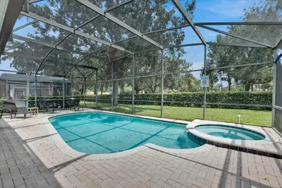 a swimming pool with a pergola next to a house at CW7713 Windsor Hills Resort Vacation Home in Orlando