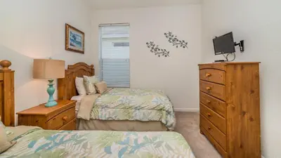 a bedroom with two beds and a dresser with a tv at CW7730 Windsor Hills Resort Vacation Home in Orlando