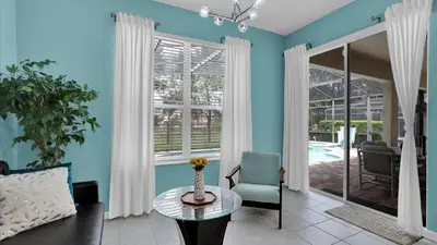 a living room with blue walls and a table and a chair at CW7739 Windsor Hills Resort Vacation Home in Orlando