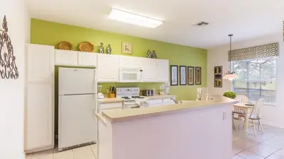 a kitchen with green walls and a white refrigerator at DB2633 Windsor Hills Resort Vacation Home in Orlando