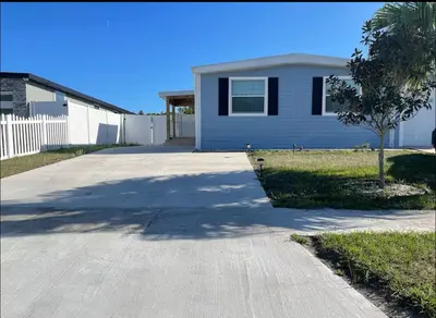 a driveway in front of a white house at Agradable casa parqueos gratis in Orlando