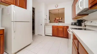 a kitchen with a white refrigerator and wooden cabinets at BNC7795 in Orlando
