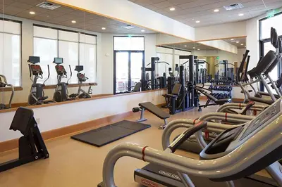 a gym with several treadmills and elliptical machines at Stunning Regal Oaks 4BR w/ Pool, Spa & Near Disney in Orlando