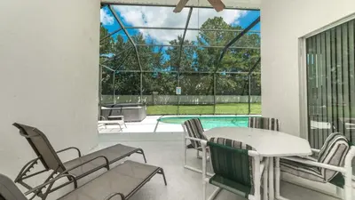 a patio with a table and chairs and a pool at KP8038 Windsor Palms Resort Vacation Home in Kissimmee