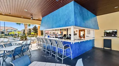 a restaurant with a blue bar with chairs and tables at CAL8967 in Kissimmee