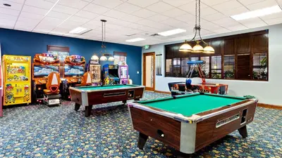 a room with two pool tables and arcade games at CAP8875 in Kissimmee