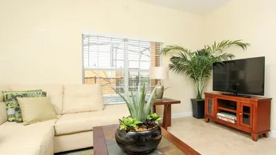 a living room with a couch and a flat screen tv at CAP8883 in Kissimmee
