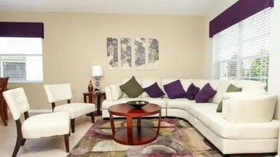 a living room with a white couch and purple pillows at Luxury 6 BR in Windsor Hill Resorts in Orlando