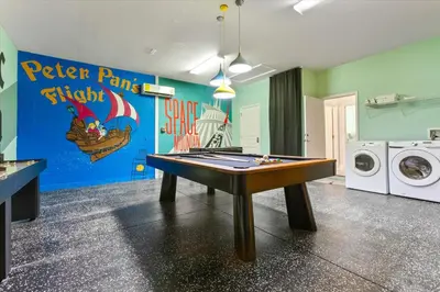 a ping pong table in a laundry room with a washer and dryer at Lavish 4BR Home in Windsor Hills Resort in Orlando