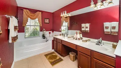 a bathroom with red walls and a tub and a sink at Huge 6BR Home in Windsor Hills Resort in Orlando