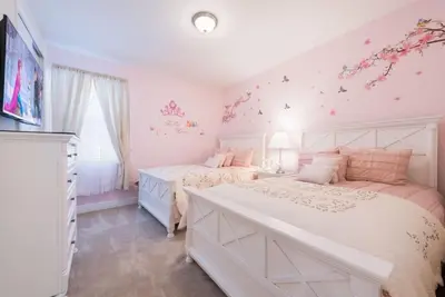 two beds in a bedroom with pink walls at Luxury 6BD Encore Resort Disney Pvt Pool Game Room Near Disney Water Park in Orlando