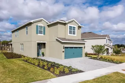 a large house with a blue garage at Luxury 6BD Encore Resort Disney Pvt Pool Game Room Near Disney Water Park in Orlando