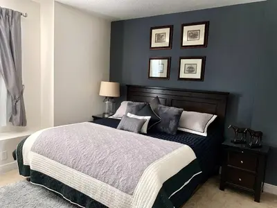 a bedroom with a large bed with blue walls at Luxury 6BD Encore Resort Disney Pvt Pool Game Room Near Disney Water Park in Orlando