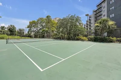 a tennis court with two tennis rackets on it at 6165 CARRIER DR #1212 ORLANDO 1BED in Orlando