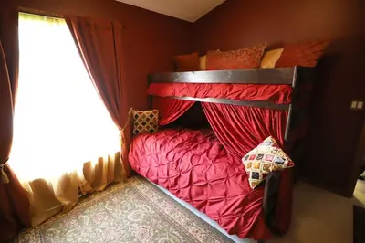 a bedroom with two bunk beds with red sheets at Magical 5-Bedroom Villa Near Universal's Wizarding World in Kissimmee