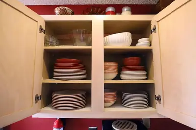 a cabinet filled with plates and bowls and dishes at Enchanted Villa with Lake View 6-Bedroom in Resort 9 miles to Disney World 15 miles to the Wizarding World of Harry Potter in Kissimmee