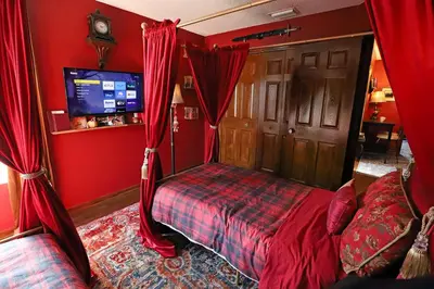 a bedroom with red walls and a bed with red curtains at Waterfront 6-Bedroom Wizarding Villa in Lake Berkley Near Universal Studio's Harry Potter in Kissimmee