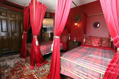 a bedroom with two beds with red drapes at Waterfront 6-Bedroom Wizarding Villa in Lake Berkley Near Universal Studio's Harry Potter in Kissimmee