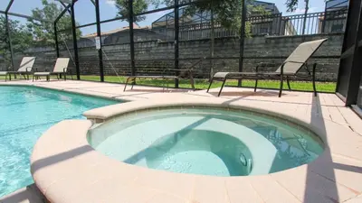 a small swimming pool with two chairs and a fence at 6-Bedroom 2505 in Orlando