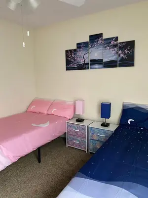 a bedroom with a pink bed and two night stands at Home Near Disney Private Pool & Playground in Howey in the Hills