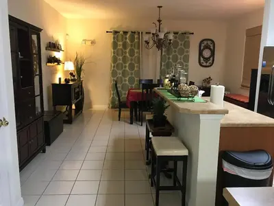 a kitchen and living room with a table and chairs at Home Near Disney Private Pool & Playground in Howey in the Hills