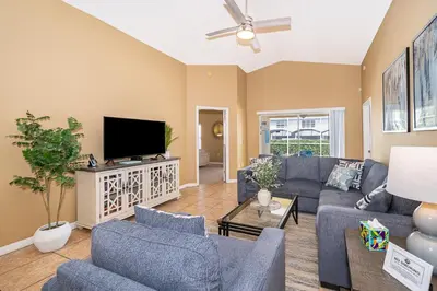 a living room with blue couches and a flat screen tv at Family-Friendly 5-Bedroom Home With Pool Near Disney in Orlando