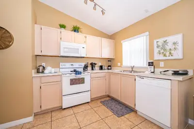 a kitchen with white appliances and a window at Family-Friendly 5-Bedroom Home With Pool Near Disney in Orlando
