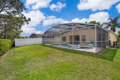 a building with a pool in a yard at Family-Friendly 5-Bedroom Home With Pool Near Disney in Orlando
