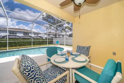 a patio with a table and chairs next to a pool at Family-Friendly 5-Bedroom Home With Pool Near Disney in Orlando