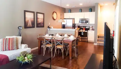 a living room with a dining room table and a kitchen at Villa Rios Camilo - Lucaya Village in Kissimmee