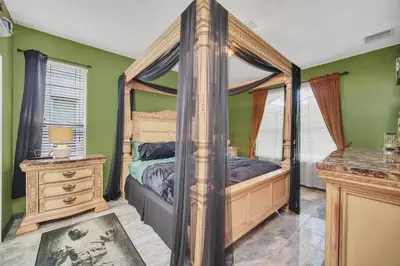 a bedroom with a canopy bed and green walls at Galactic 7-Bedroom Villa 3 Miles to Disney Star Wars Galaxy Edge in Kissimmee