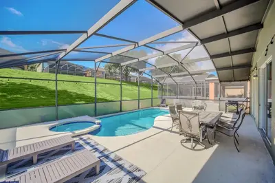 a patio with a pool and a table and chairs at Galactic 7-Bedroom Villa 3 Miles to Disney Star Wars Galaxy Edge in Kissimmee