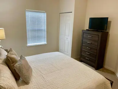 a bedroom with a bed and a television on a dresser at Villa Magic- Lucaya Villa Resort in Kissimmee