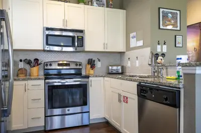 a kitchen with white cabinets and a stainless steel appliance at Villa Hakuna Matata- Lucaya Village Resort in Kissimmee