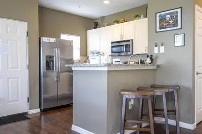 a kitchen with a refrigerator and two bar stools at Villa Hakuna Matata- Lucaya Village Resort in Kissimmee
