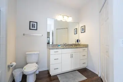 a bathroom with a toilet and a sink and a mirror at Villa Hakuna Matata- Lucaya Village Resort in Kissimmee