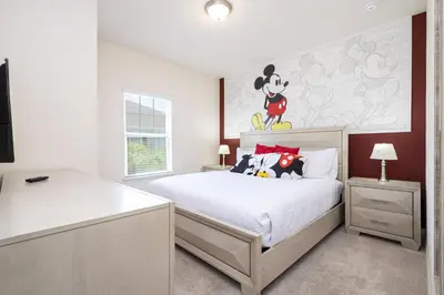a bedroom with a bed with a mickey mouse painting on the wall at Villa Coelho - West Lucaya Resort in Kissimmee