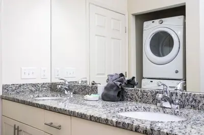 a bathroom with two sinks and a washing machine at Villa Coelho - West Lucaya Resort in Kissimmee