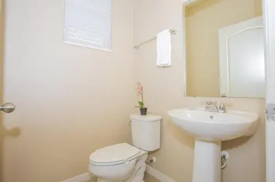 a bathroom with a white toilet and a sink at Villa Compass- Compass Bay in Kissimmee