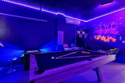 a pool table in a room with purple lights at 261 LASSO DRIVE 6BED in Orlando