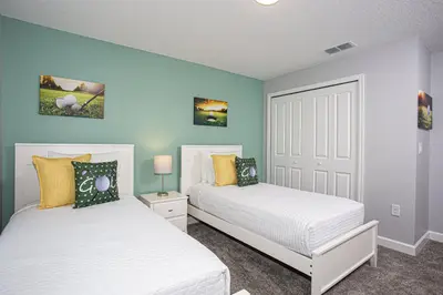 two beds in a bedroom with blue walls at Villa Ariel- Storey Lake in Kissimmee
