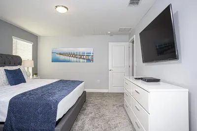 a bedroom with a bed and a flat screen tv at Villa Ariel- Storey Lake in Kissimmee