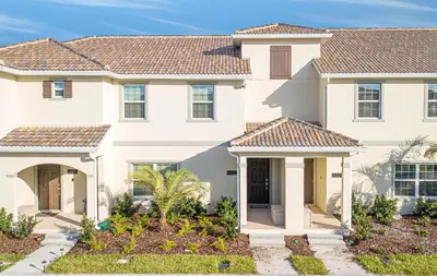 a large white house with landscaping at Villa Ariel- Storey Lake in Kissimmee