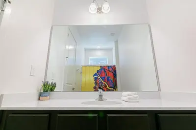 a bathroom with a sink and a large mirror at 2476 SHANTI DRIVE 12BED in Kissimmee