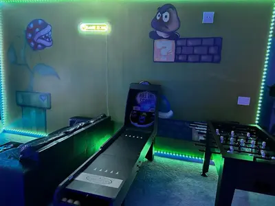 a room with a gaming machine in a room with green lights at 2476 SHANTI DRIVE 12BED in Kissimmee